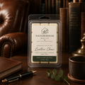 Leather Chair Wax Melts by Naturehouse Wax Co displayed on a wooden table with a leather chair and vintage books in the background, emphasizing a cozy, classic atmosphere.