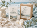 Tidal Breeze Wax Melts packaging by Naturehouse Wax Company displayed with wax cubes and a ceramic wax warmer, styled with natural elements evoking a coastal, fresh scent.