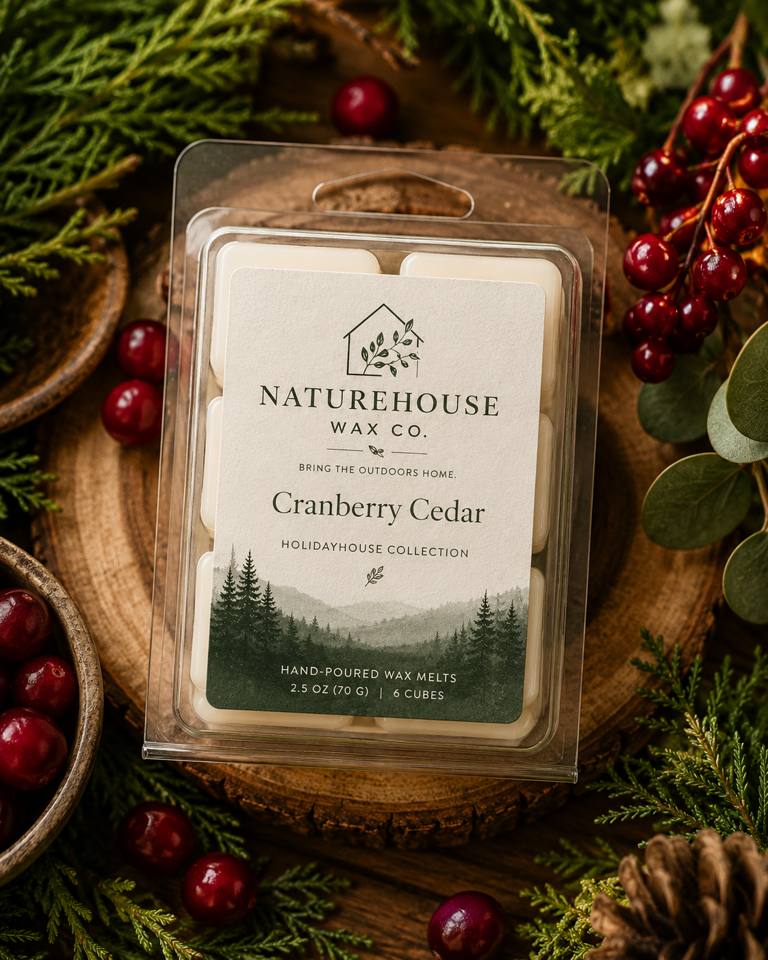 Clear plastic clamshell package of Cranberry Cedar Wax Melts by Naturehouse Wax Company, surrounded by fresh cranberries, cedar branches, and pine cones on a wooden surface.